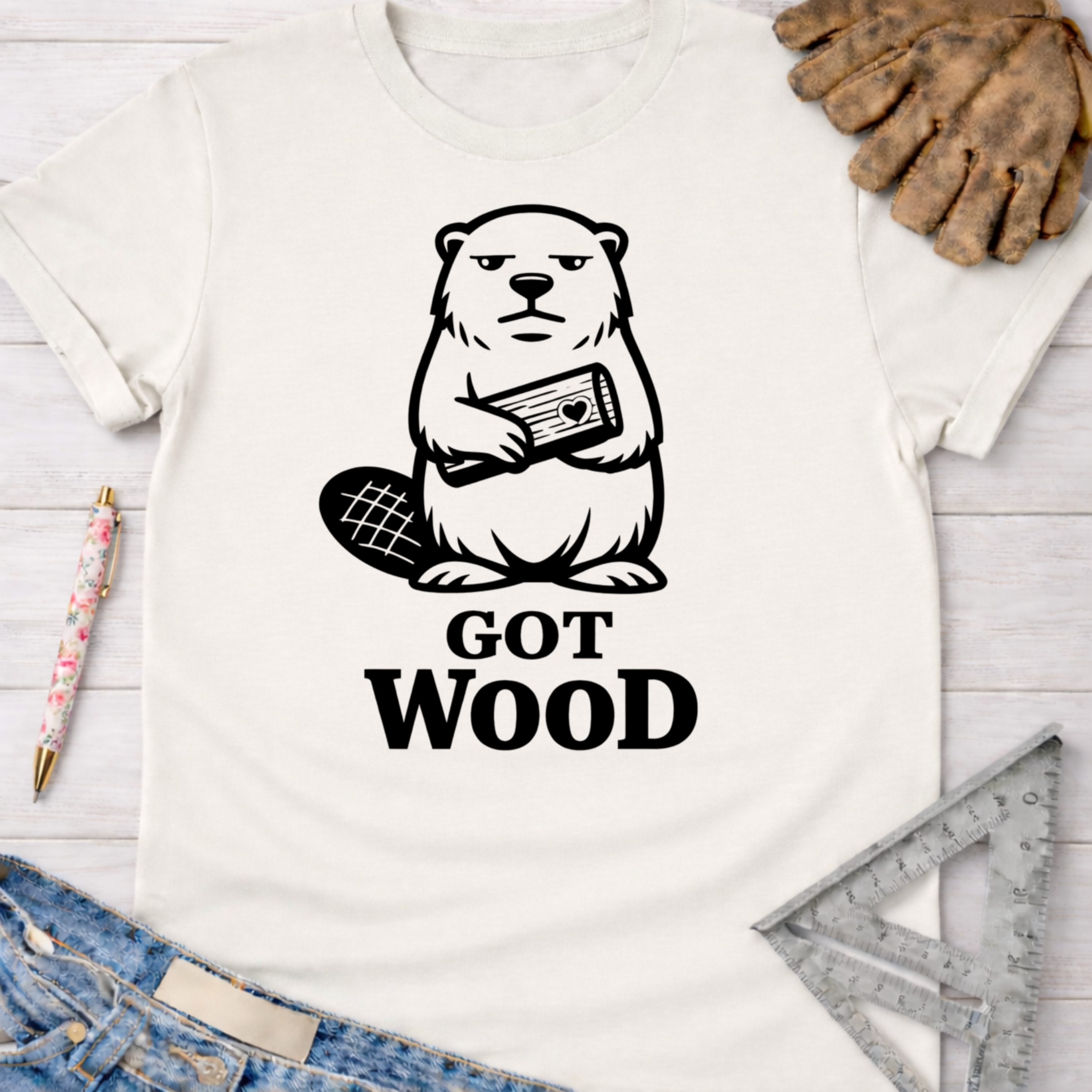 Women's funny woodworking graphic tee shirt for female woodworkers, makers, and DIY builders — Sawdust & Ponytails. White cotton tee with a black beaver holding wood and "GOT WOOD" text.