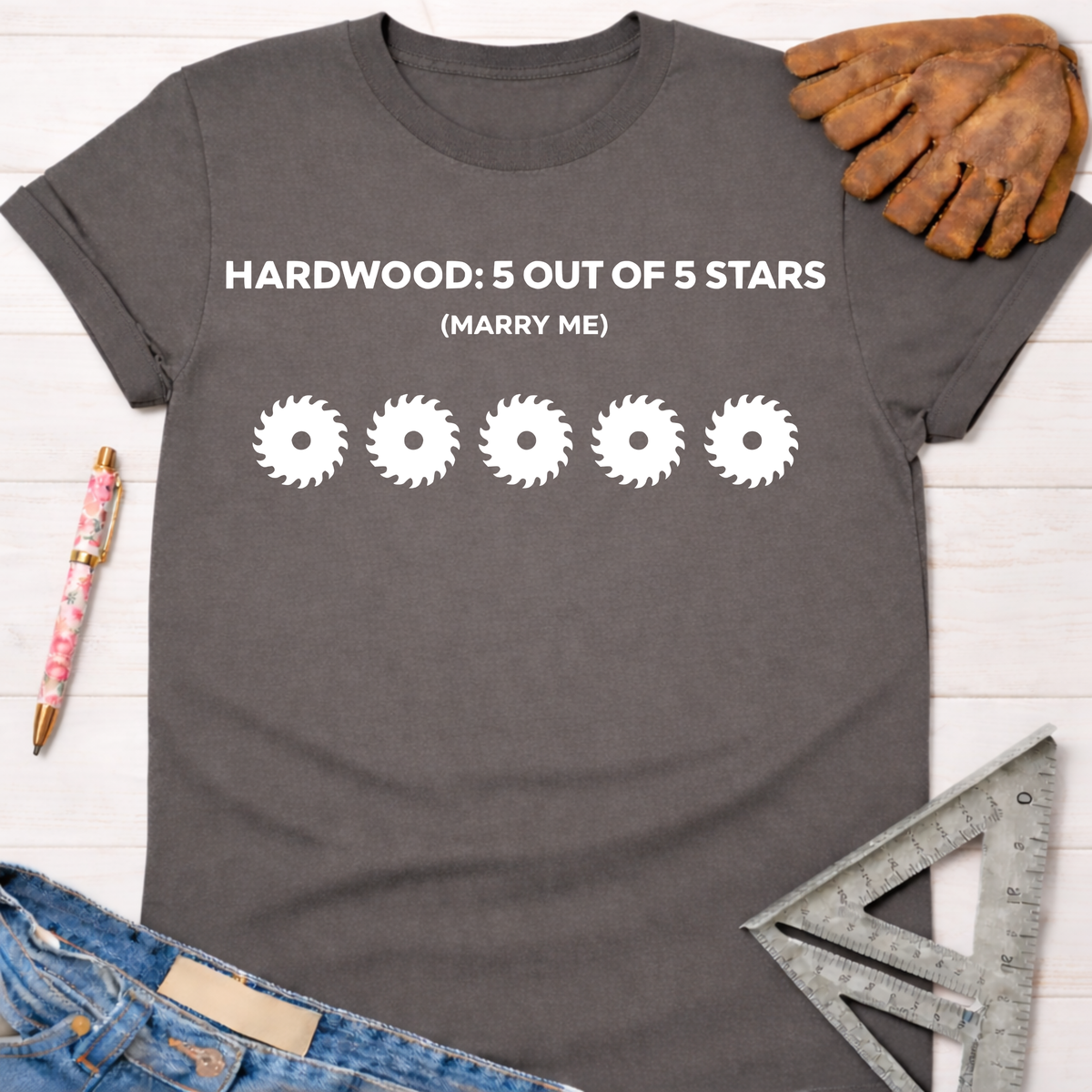 Women's funny woodworking graphic tee shirt for female woodworkers, makers, and DIY builders — Sawdust & Ponytails. Dark gray cotton tee with "HARDWOOD: 5 OUT OF 5 STARS (MARRY ME)" and five saw blade graphics.