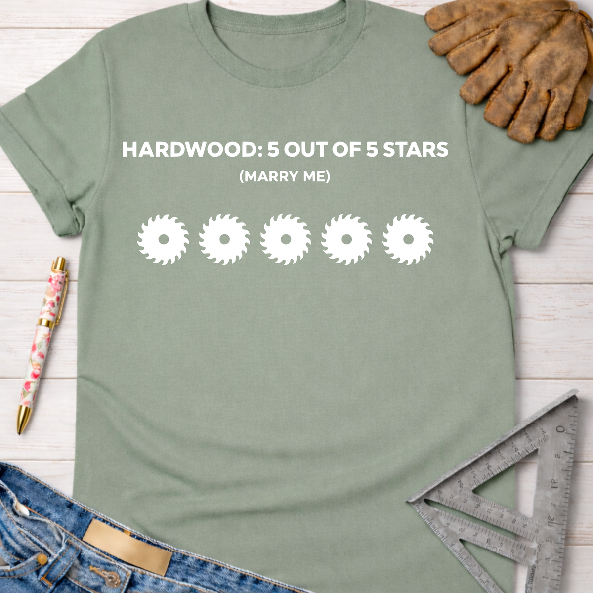 Women's funny woodworking graphic tee shirt for female woodworkers, makers, and DIY builders — Sawdust & Ponytails. Sage green cotton tee with "HARDWOOD: 5 OUT OF 5 STARS (MARRY ME)" and five saw blade graphics.