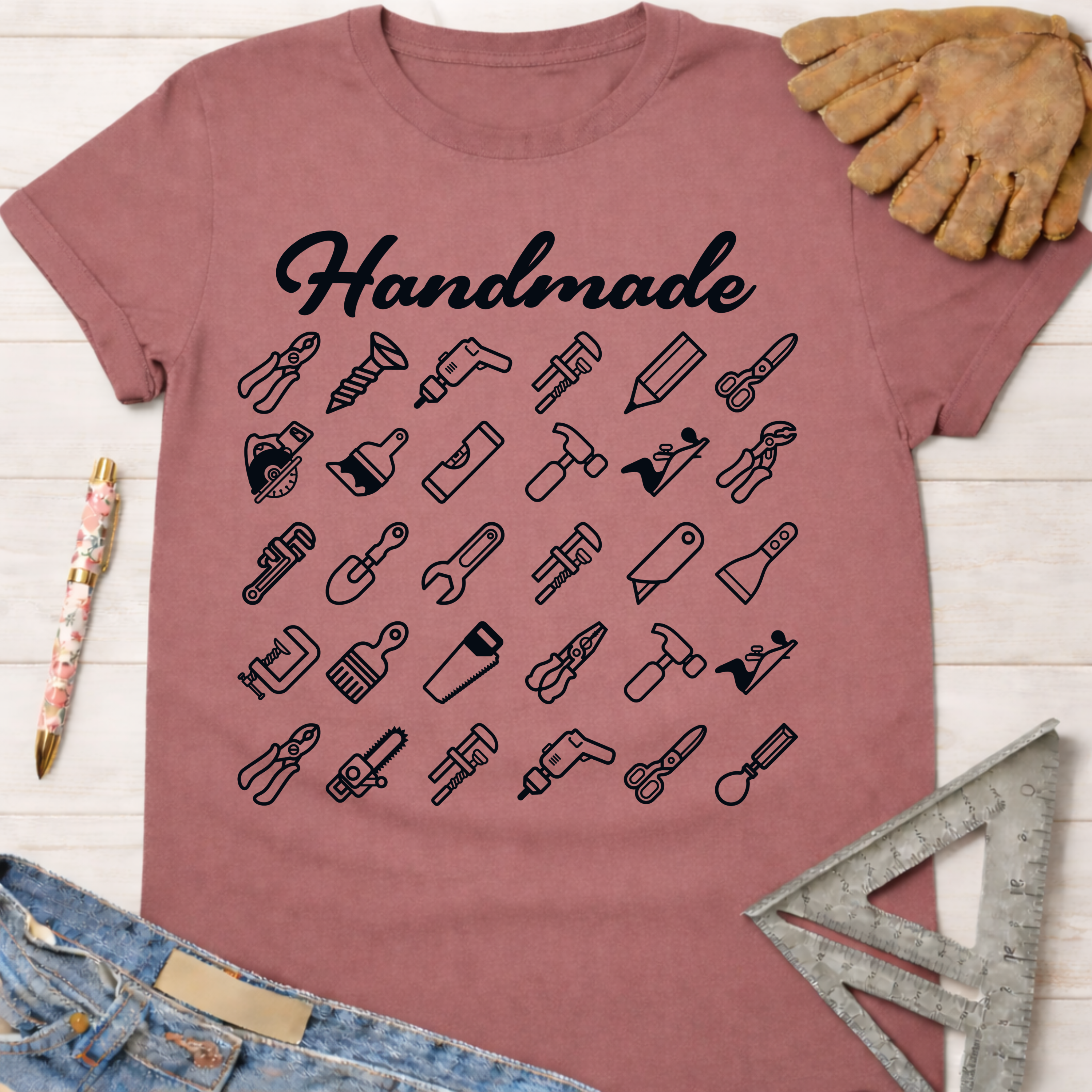 Women's funny woodworking graphic tee shirt for female woodworkers, makers, and DIY builders — Sawdust & Ponytails. Mauve t-shirt with "Handmade" and tool icons.