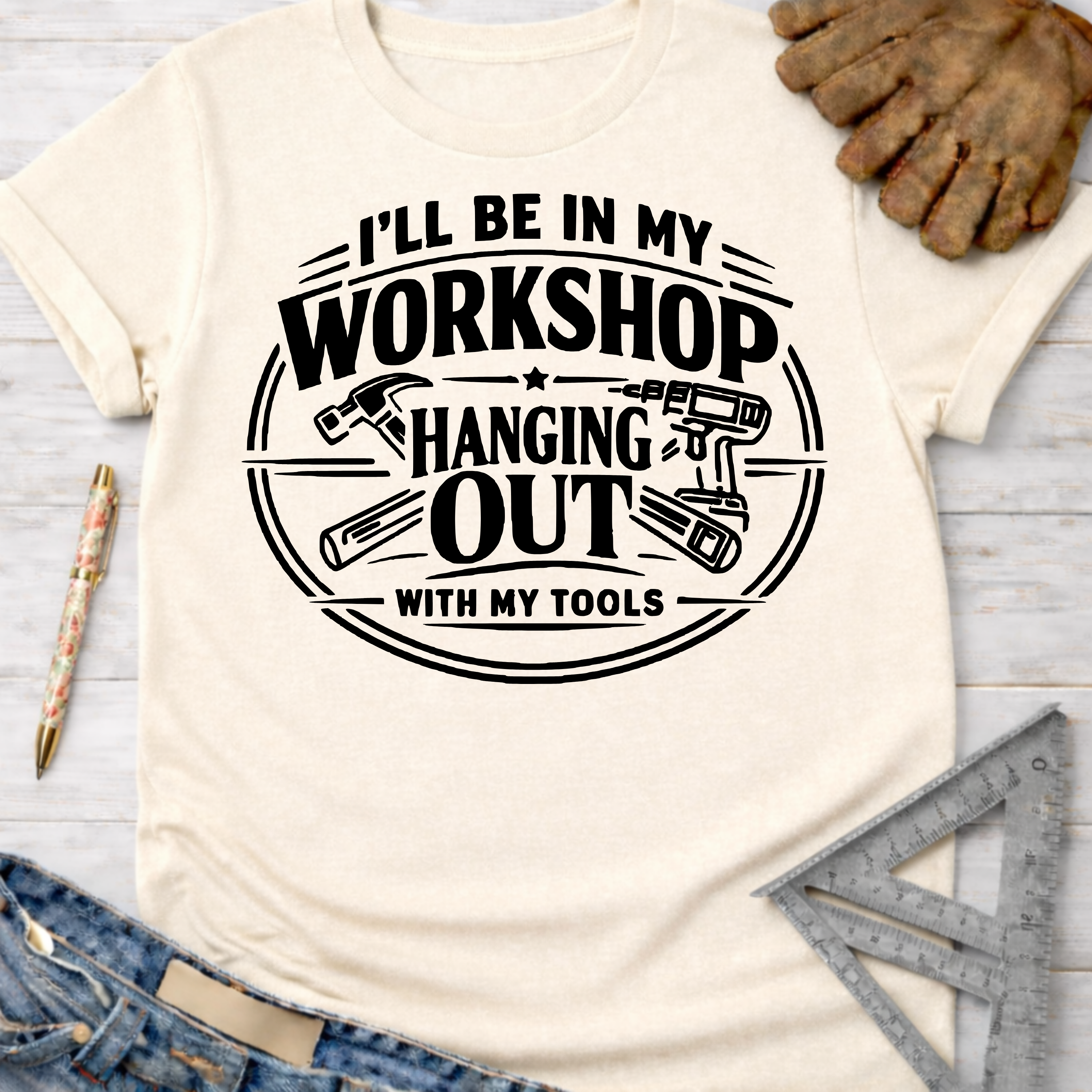 Women's funny woodworking graphic tee shirt for female woodworkers, makers, and DIY builders — Sawdust & Ponytails. Cream t-shirt with "I'll Be In My Workshop Hanging Out With My Tools" graphic.