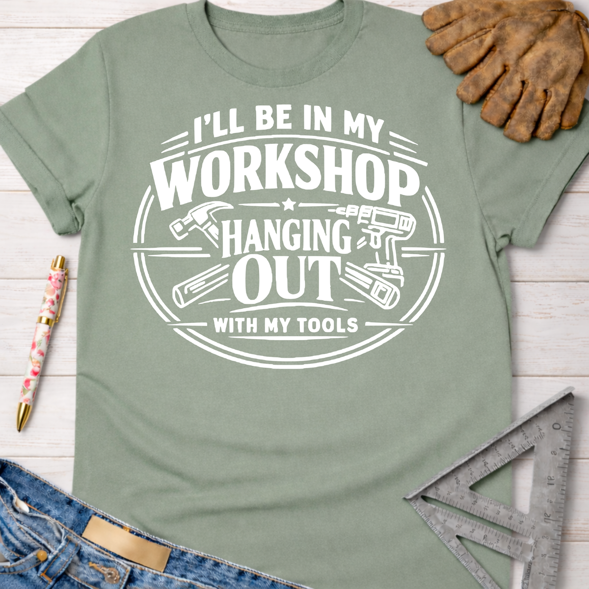 Sage green women's funny woodworking graphic tee with "I'll be in my workshop hanging out with my tools" design.