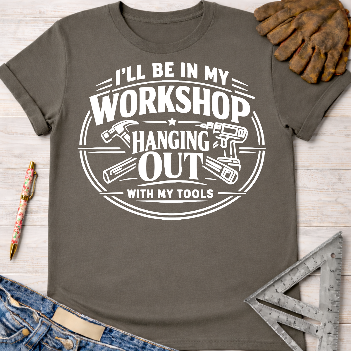 Women's funny woodworking graphic tee shirt for female woodworkers, makers, and DIY builders — Sawdust & Ponytails. Dark gray cotton tee with "I'll Be In My Workshop Hanging Out With My Tools" graphic.