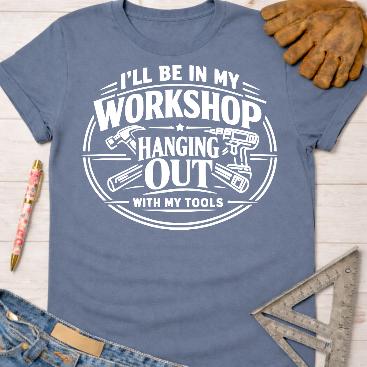Women's funny woodworking graphic tee shirt for female woodworkers, makers, and DIY builders — Sawdust & Ponytails. Blue cotton tee with "I'll Be In My Workshop Hanging Out With My Tools" graphic.
