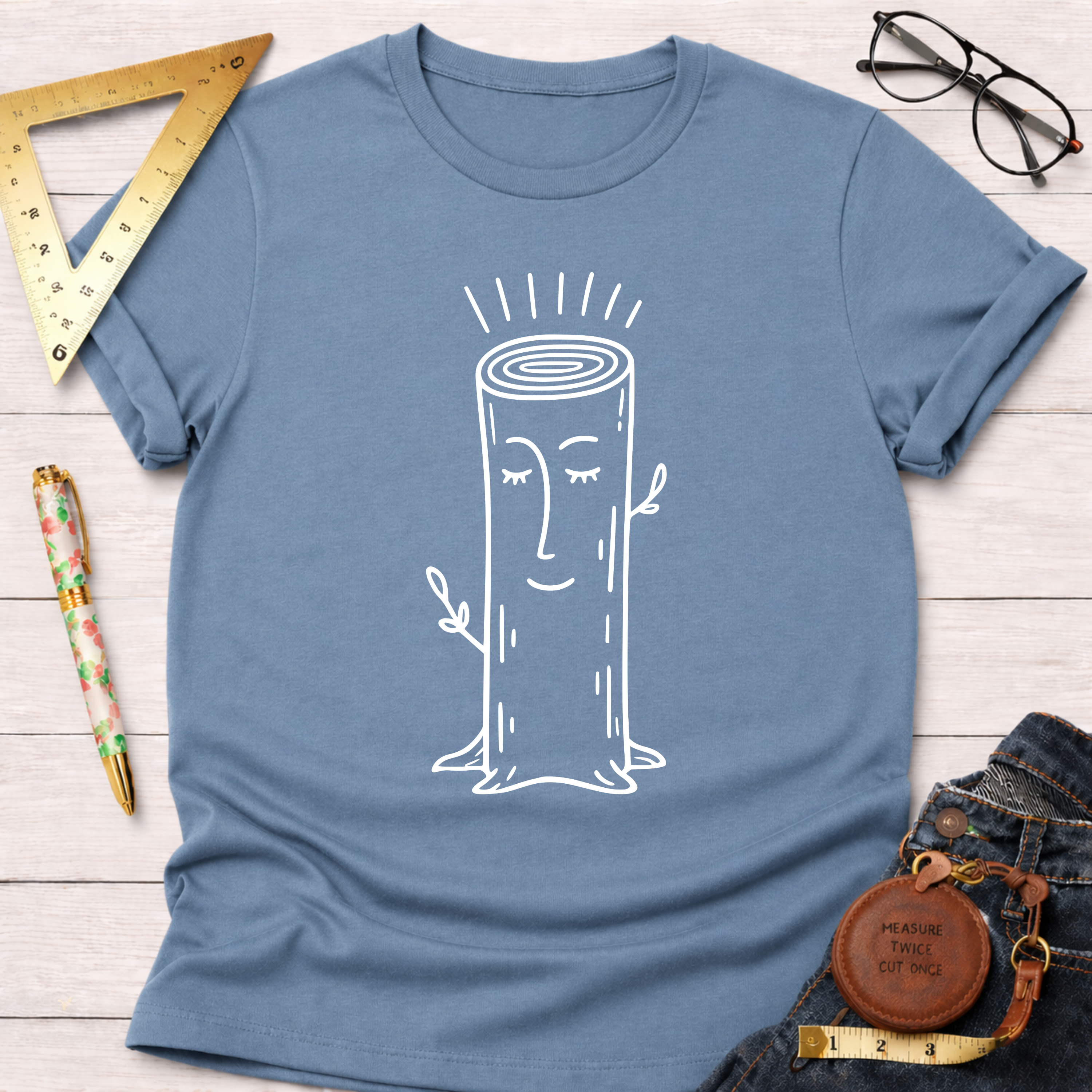Women's funny woodworking graphic tee shirt for female woodworkers, makers, and DIY builders — Sawdust & Ponytails. Blue cotton tee with a white smiling tree stump graphic.