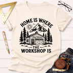 Women's funny woodworking graphic tee shirt for female woodworkers, makers, and DIY builders — Sawdust & Ponytails. Cream cotton t-shirt with "Home Is Where The Workshop Is" graphic.
