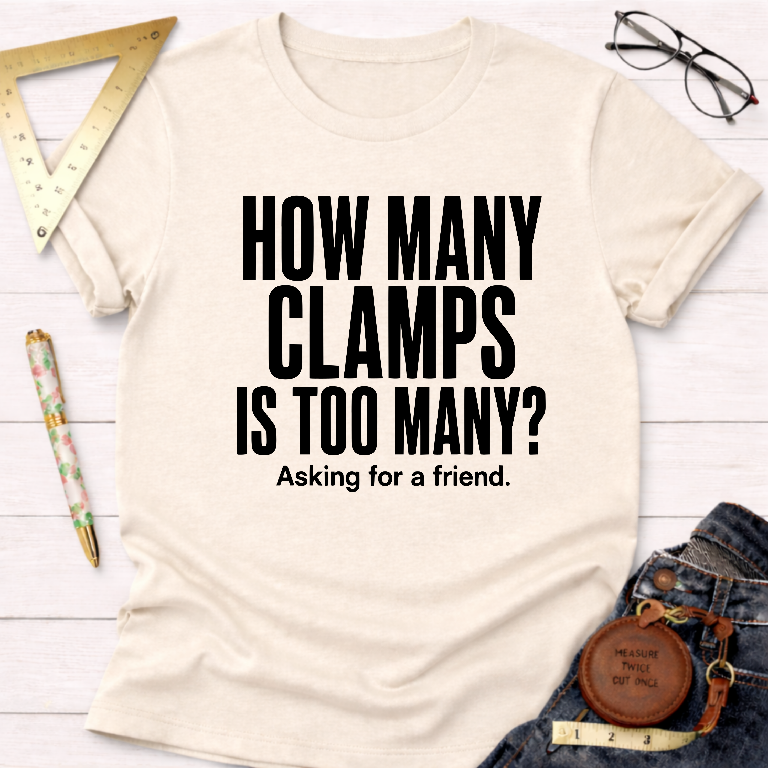 Cream t-shirt with "HOW MANY CLAMPS IS TOO MANY? Asking for a friend." in black text.