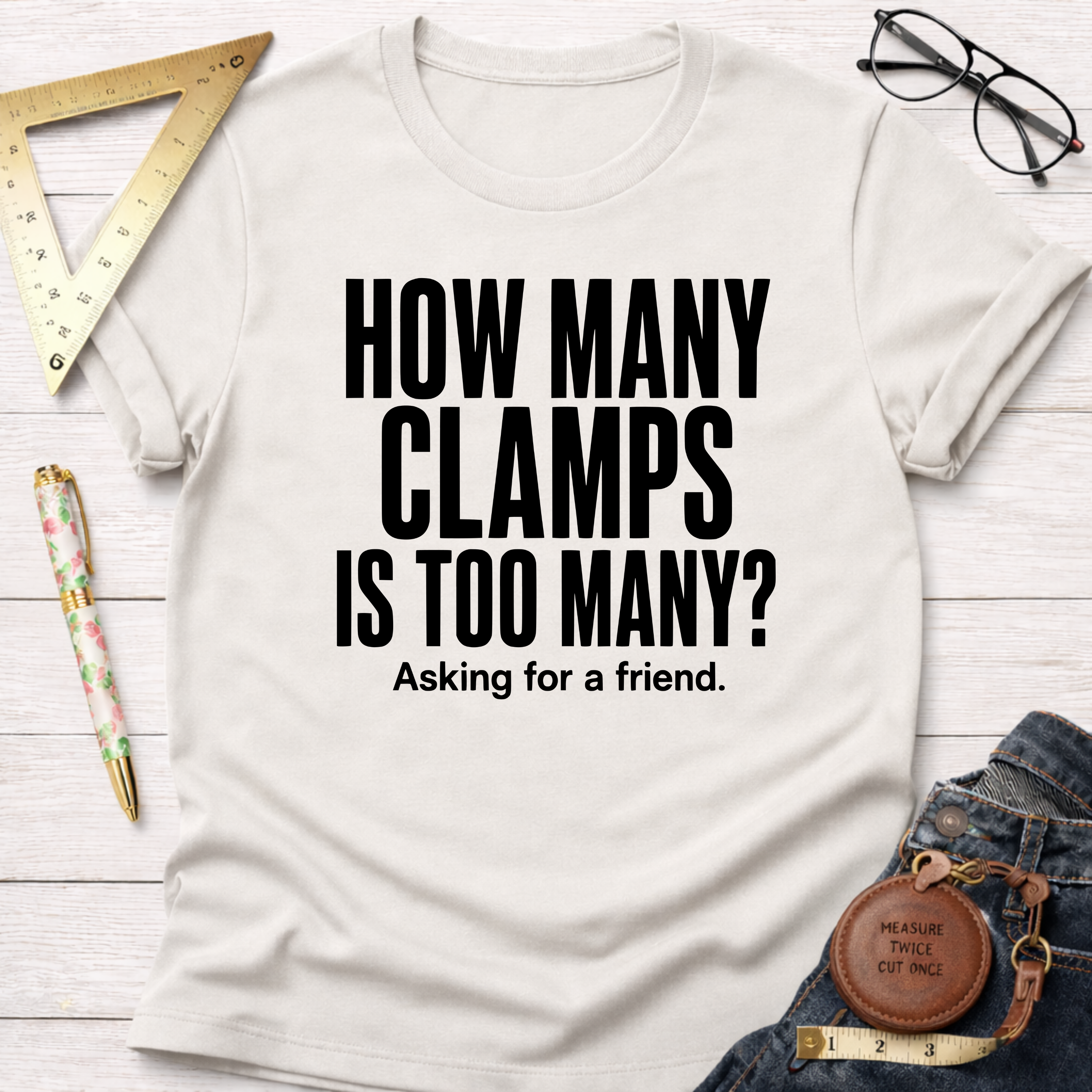 Off-white cotton t-shirt with "How Many Clamps Is Too Many? Asking for a friend." in black text.