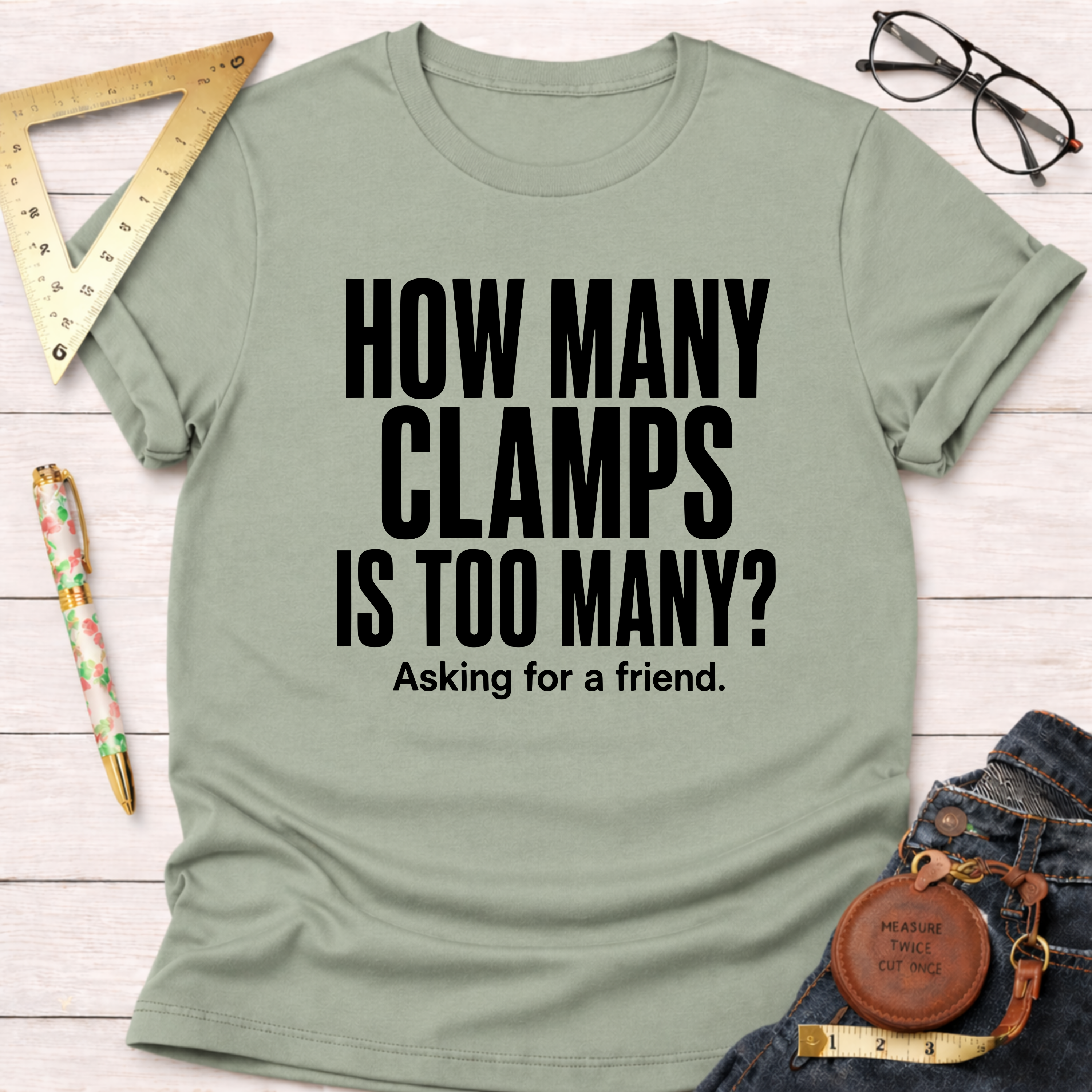 Sage green t-shirt with "HOW MANY CLAMPS IS TOO MANY? Asking for a friend." in black text.