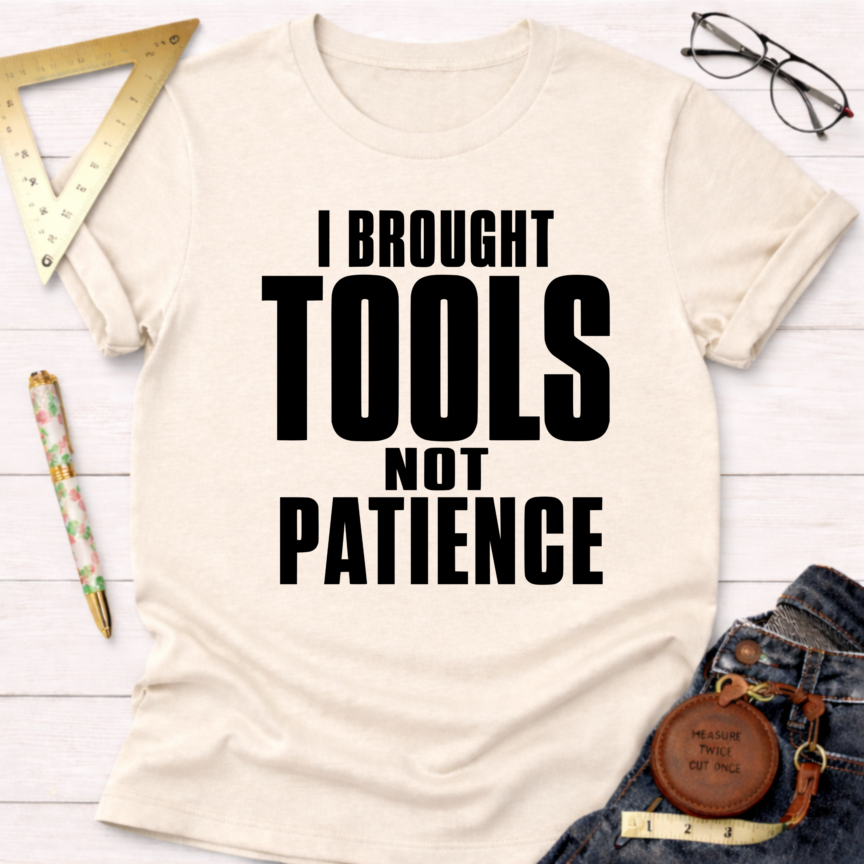 Women's funny woodworking graphic tee shirt for female woodworkers, makers, and DIY builders — Sawdust & Ponytails. Cream t-shirt with "I BROUGHT TOOLS NOT PATIENCE" in bold black text.