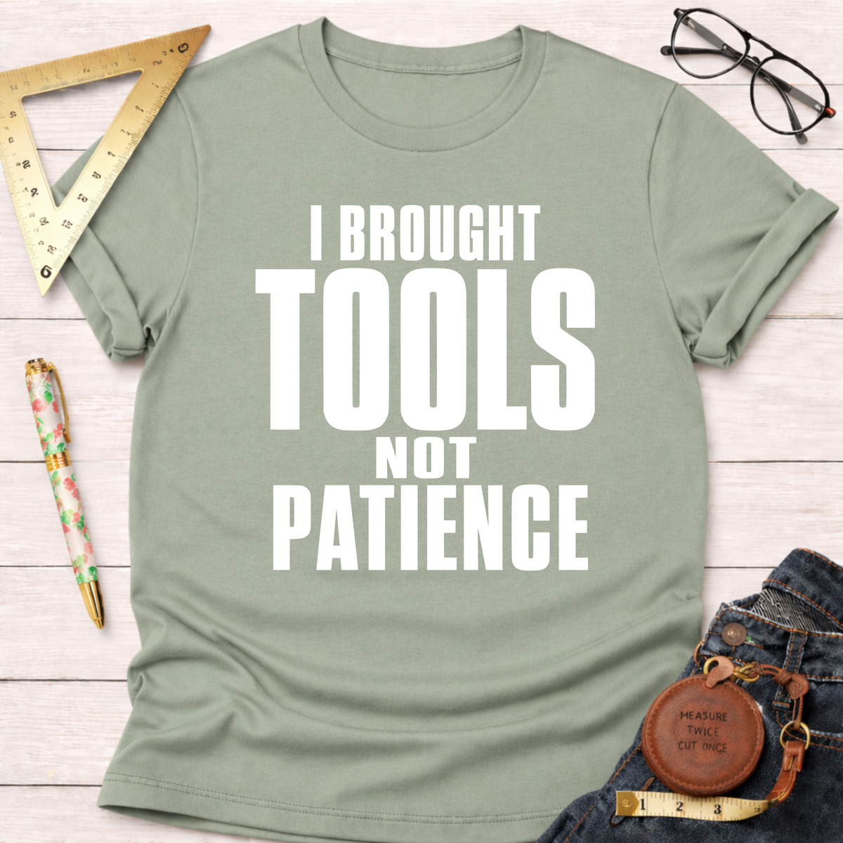 Women's funny woodworking graphic tee shirt for female woodworkers, makers, and DIY builders — Sawdust & Ponytails. Sage green t-shirt with "I BROUGHT TOOLS NOT PATIENCE" in white text.