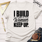 White cotton t-shirt with "I BUILD like a Woman. KEEP UP." in black text, styled with tools.