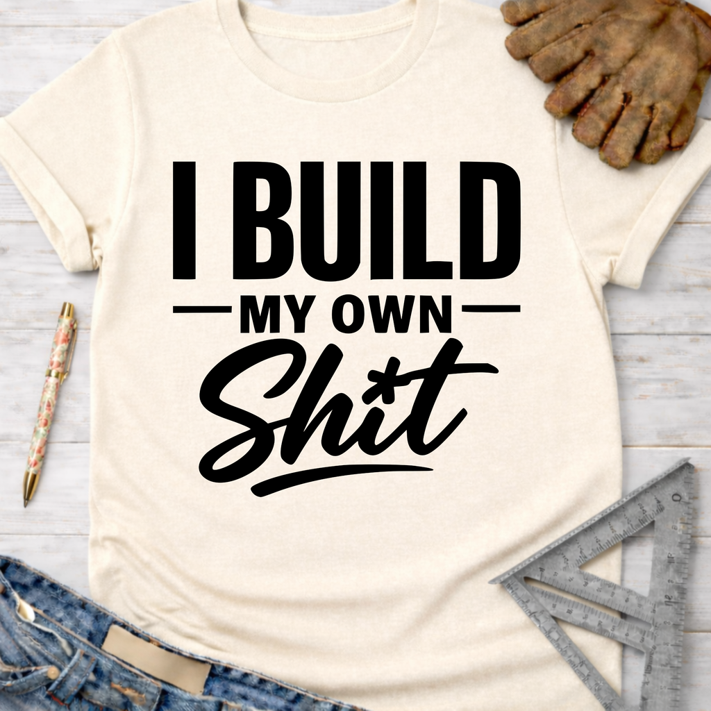 Women's funny woodworking graphic tee shirt for female woodworkers, makers, and DIY builders — Sawdust & Ponytails. Cream t-shirt with "I BUILD MY OWN Shit" in bold black text.