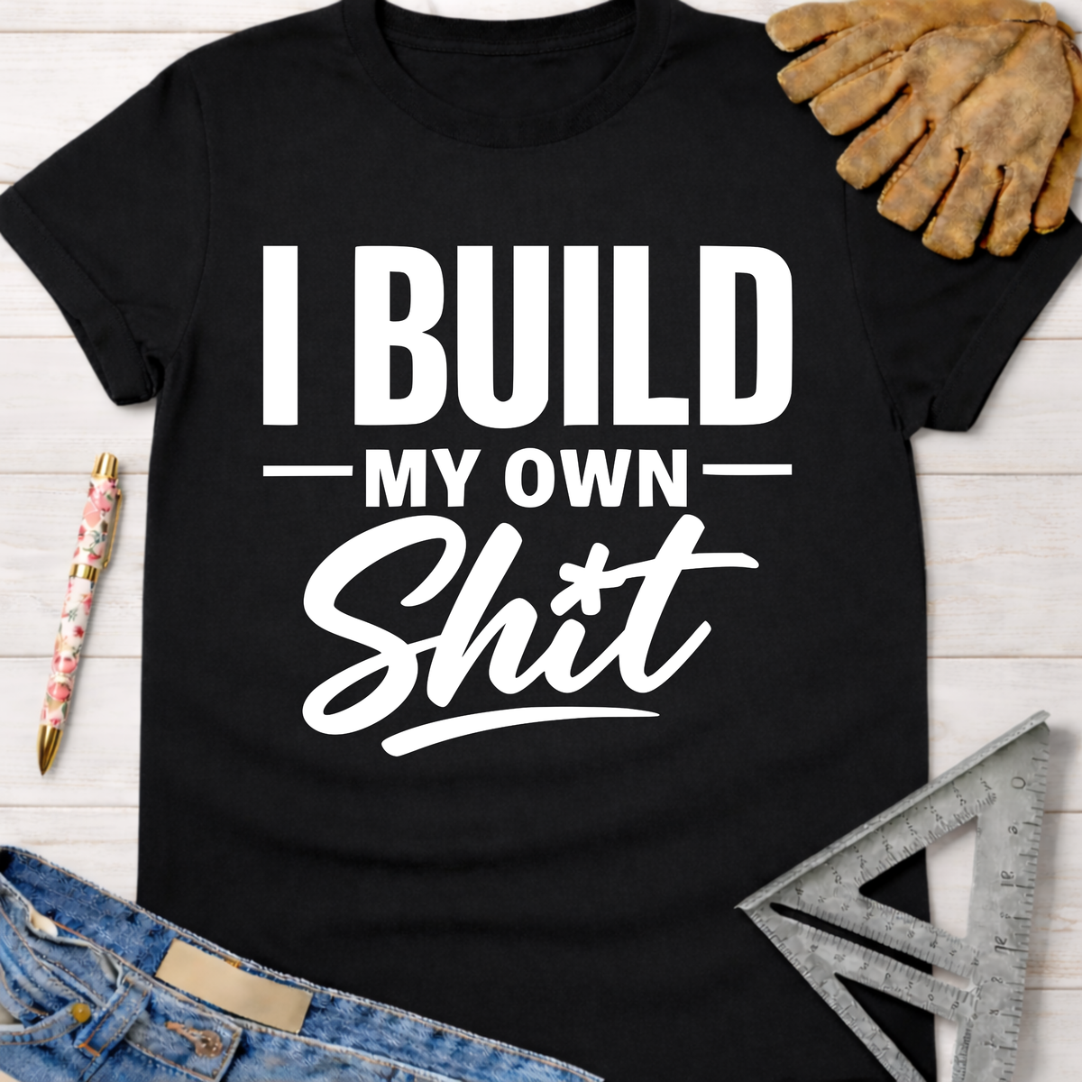 Women's funny woodworking graphic tee shirt for female woodworkers, makers, and DIY builders — Sawdust & Ponytails. Black cotton crewneck t-shirt with "I BUILD MY OWN Shit" in white text.