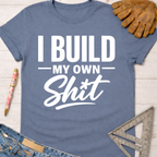 Women's funny woodworking graphic tee shirt for female woodworkers, makers, and DIY builders — Sawdust & Ponytails. Blue short-sleeve t-shirt with "I Build My Own Shit" in white text.