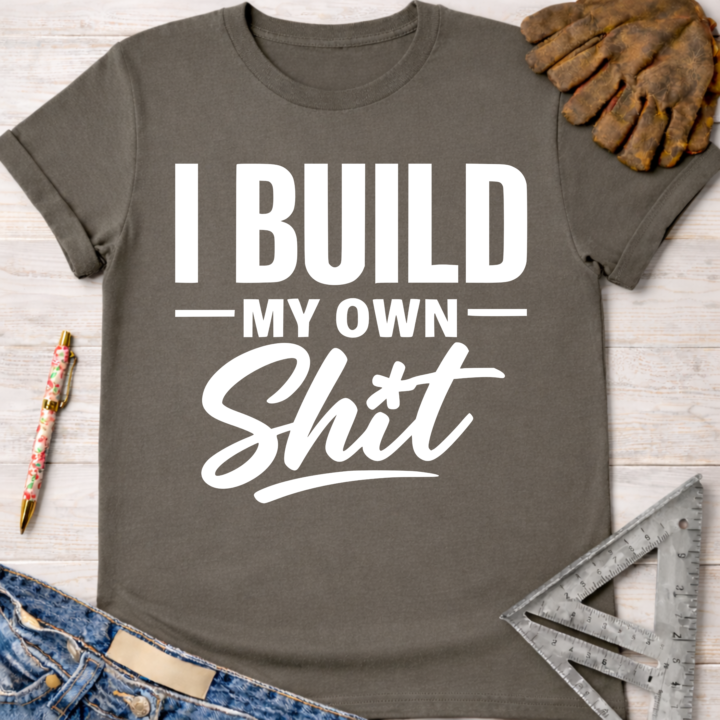 Women's funny woodworking graphic tee shirt for female woodworkers, makers, and DIY builders — Sawdust & Ponytails. Dark gray t-shirt with "I BUILD MY OWN Shit" in white text.