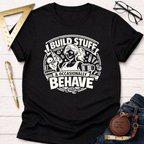 Black cotton t-shirt with "I Build Stuff & Occasionally Behave" graphic featuring a woman with a drill and coffee.