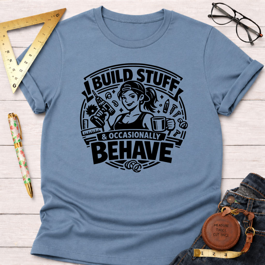 Light blue cotton t-shirt with "I Build Stuff & Occasionally Behave" graphic featuring a woman with tools.