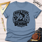 Light blue cotton t-shirt with "I Build Stuff & Occasionally Behave" graphic featuring a woman with tools.