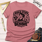 Heather dusty rose t-shirt with "I Build Stuff & Occasionally Behave" graphic featuring a woman with a drill and coffee.