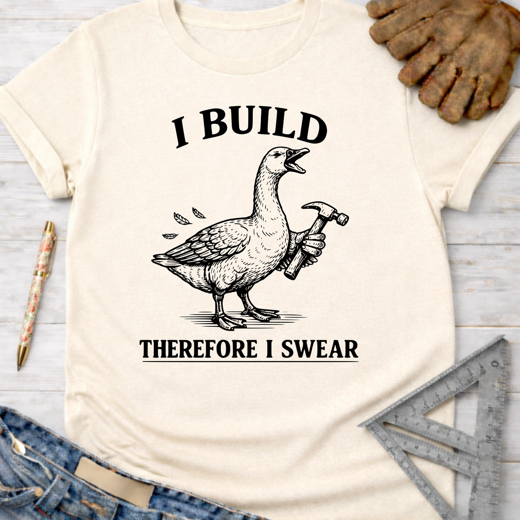 Women's funny woodworking graphic tee shirt for female woodworkers, makers, and DIY builders — Sawdust & Ponytails. Cream t-shirt with a goose holding a hammer and "I BUILD THEREFORE I SWEAR" text.