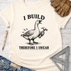 Women's funny woodworking graphic tee shirt for female woodworkers, makers, and DIY builders — Sawdust & Ponytails. Cream t-shirt with a goose holding a hammer and "I BUILD THEREFORE I SWEAR" text.