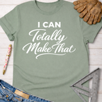 Sage green women's "I Can Totally Make That" graphic tee, with jeans, work gloves, and a ruler.