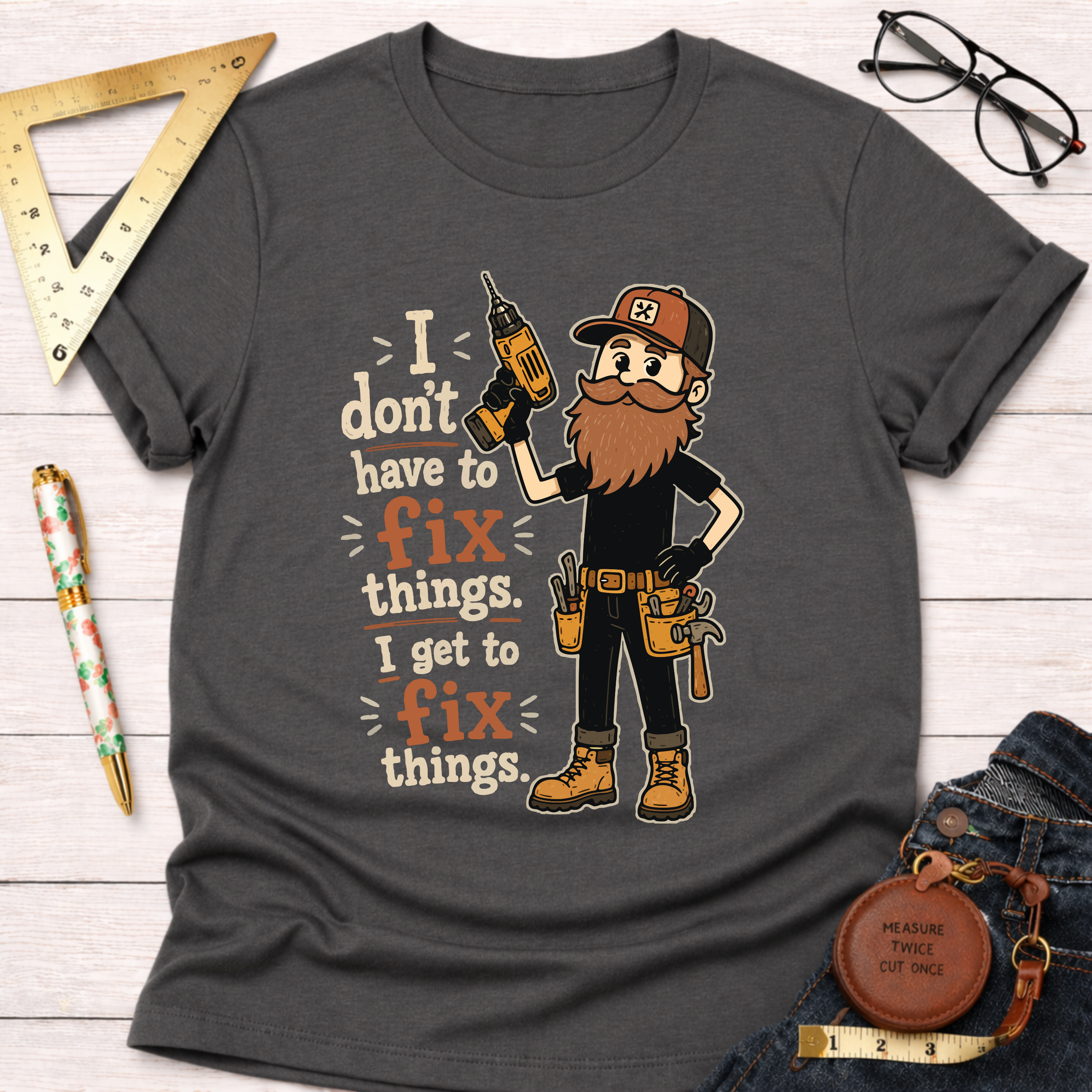 Charcoal grey cotton t-shirt with a bearded carpenter holding a drill and the text "I don't have to fix things. I get to fix things.