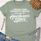 Women's funny woodworking graphic tee shirt for female woodworkers, makers, and DIY builders — Sawdust & Ponytails. Sage green cotton t-shirt with "I Enjoy Long Romantic Walks Through The Hardware Store" in white text.