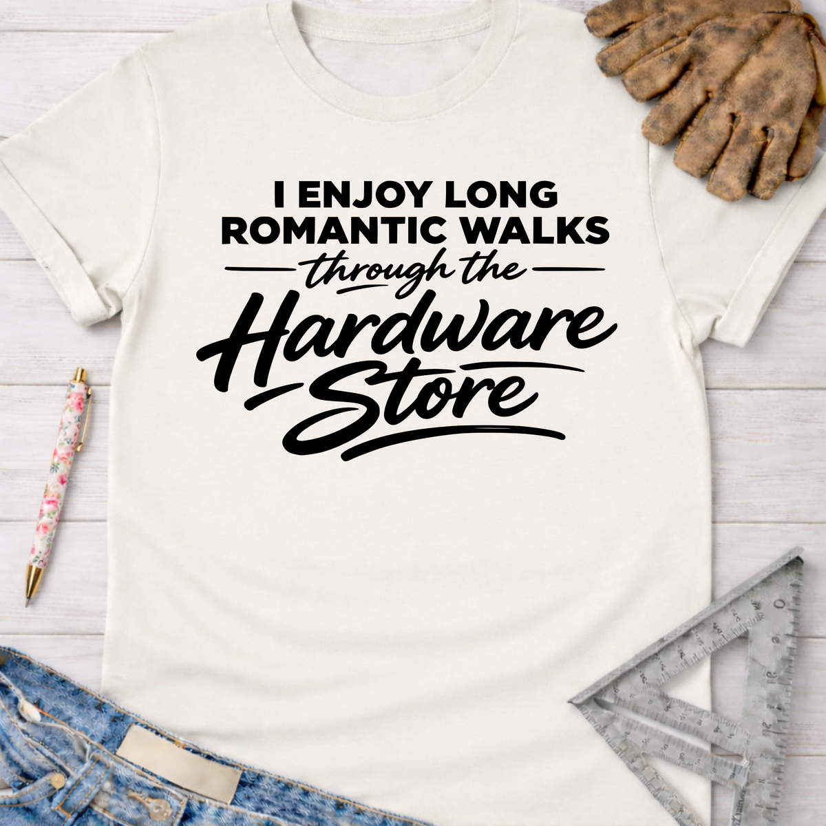 Women's funny woodworking graphic tee shirt for female woodworkers, makers, and DIY builders — Sawdust & Ponytails. White cotton short-sleeve t-shirt with "I Enjoy Long Romantic Walks Through The Hardware Store" in black text.