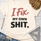 Women's funny woodworking graphic tee shirt for female woodworkers, makers, and DIY builders — Sawdust & Ponytails. Cream t-shirt with "I Fix My Own Shit" in red and black text.