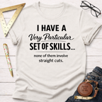 White cotton t-shirt with "I Have A Very Particular Set Of Skills... none of them involve straight cuts." text.
