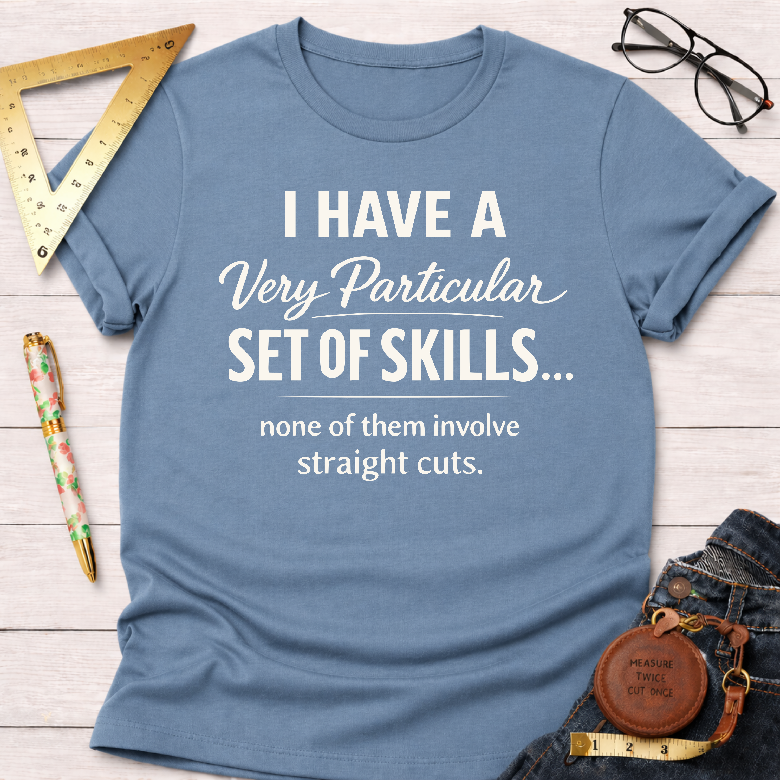 Light blue cotton t-shirt with "I Have A Very Particular Set Of Skills... none of them involve straight cuts." text.