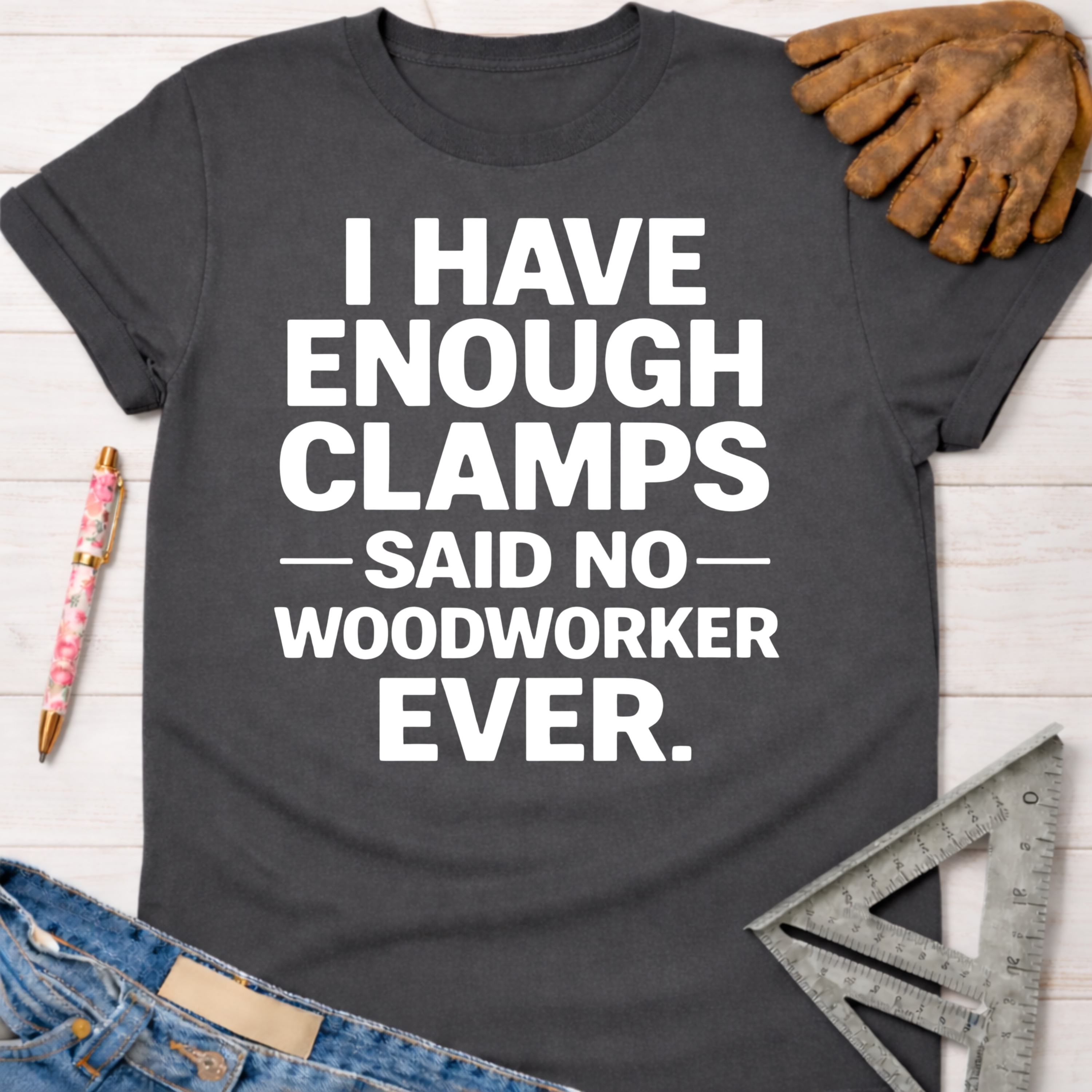 Women's funny woodworking graphic tee shirt for female woodworkers, makers, and DIY builders — Sawdust & Ponytails. Dark gray cotton t-shirt with "I HAVE ENOUGH CLAMPS — SAID NO — WOODWORKER EVER." in white text.