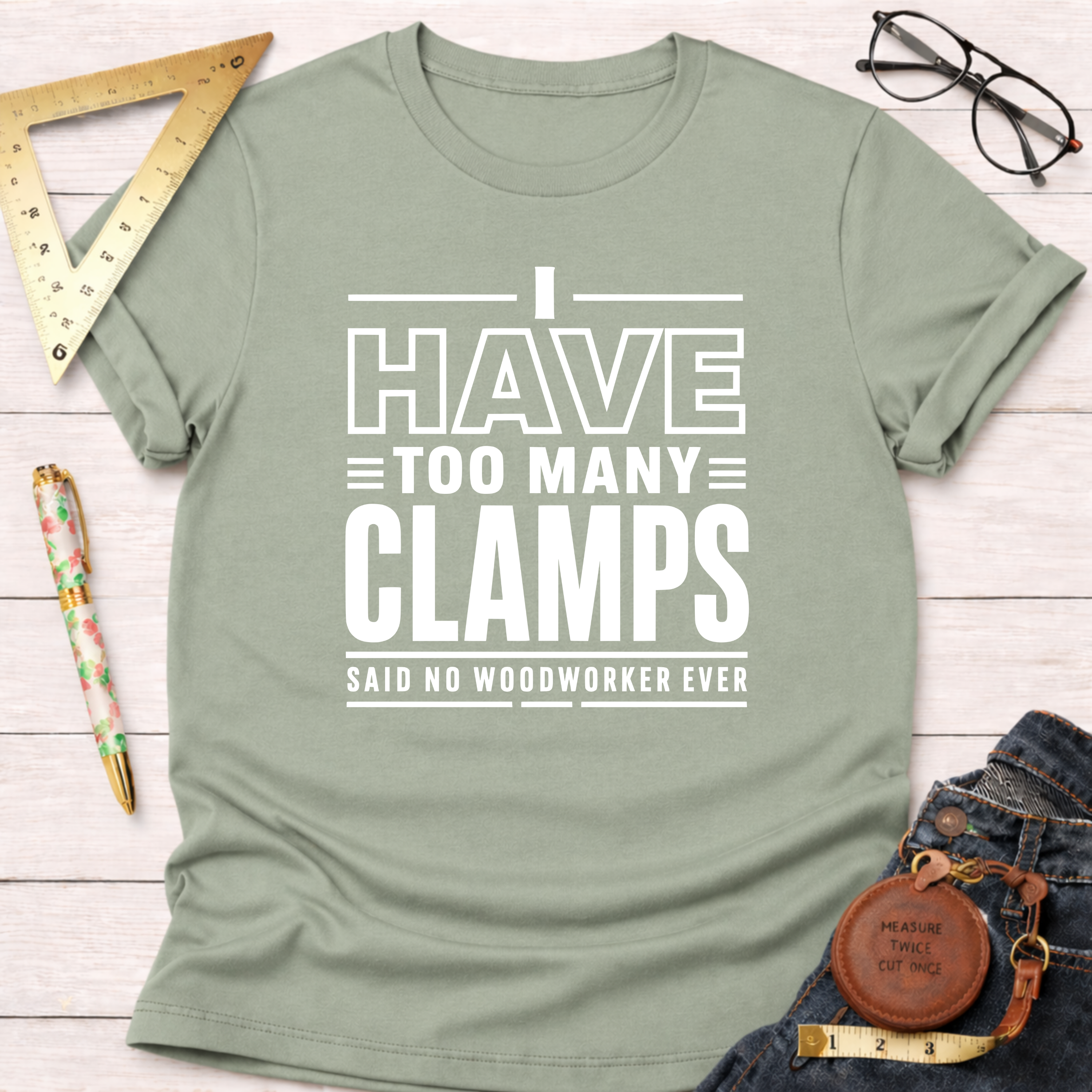 Sage green cotton t-shirt with "I Have Too Many Clamps Said No Woodworker Ever" in white text.