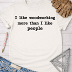 Women's funny woodworking graphic tee shirt for female woodworkers, makers, and DIY builders — Sawdust & Ponytails. White cotton tee with "I like woodworking more than I like people" text.