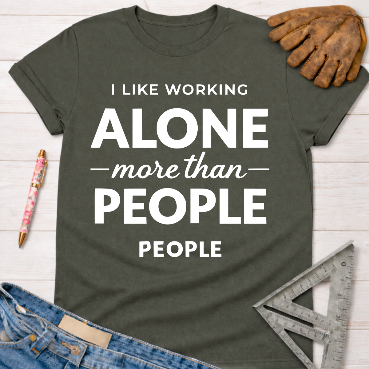 Women's funny woodworking graphic tee shirt for female woodworkers, makers, and DIY builders — Sawdust & Ponytails. Dark gray cotton tee with "I LIKE WORKING ALONE more than PEOPLE" in white text.