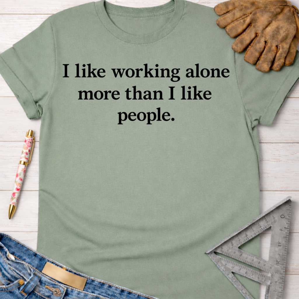 Women's funny woodworking graphic tee shirt for female woodworkers, makers, and DIY builders — Sawdust & Ponytails. Sage green cotton tee with "I like working alone more than I like people" text.