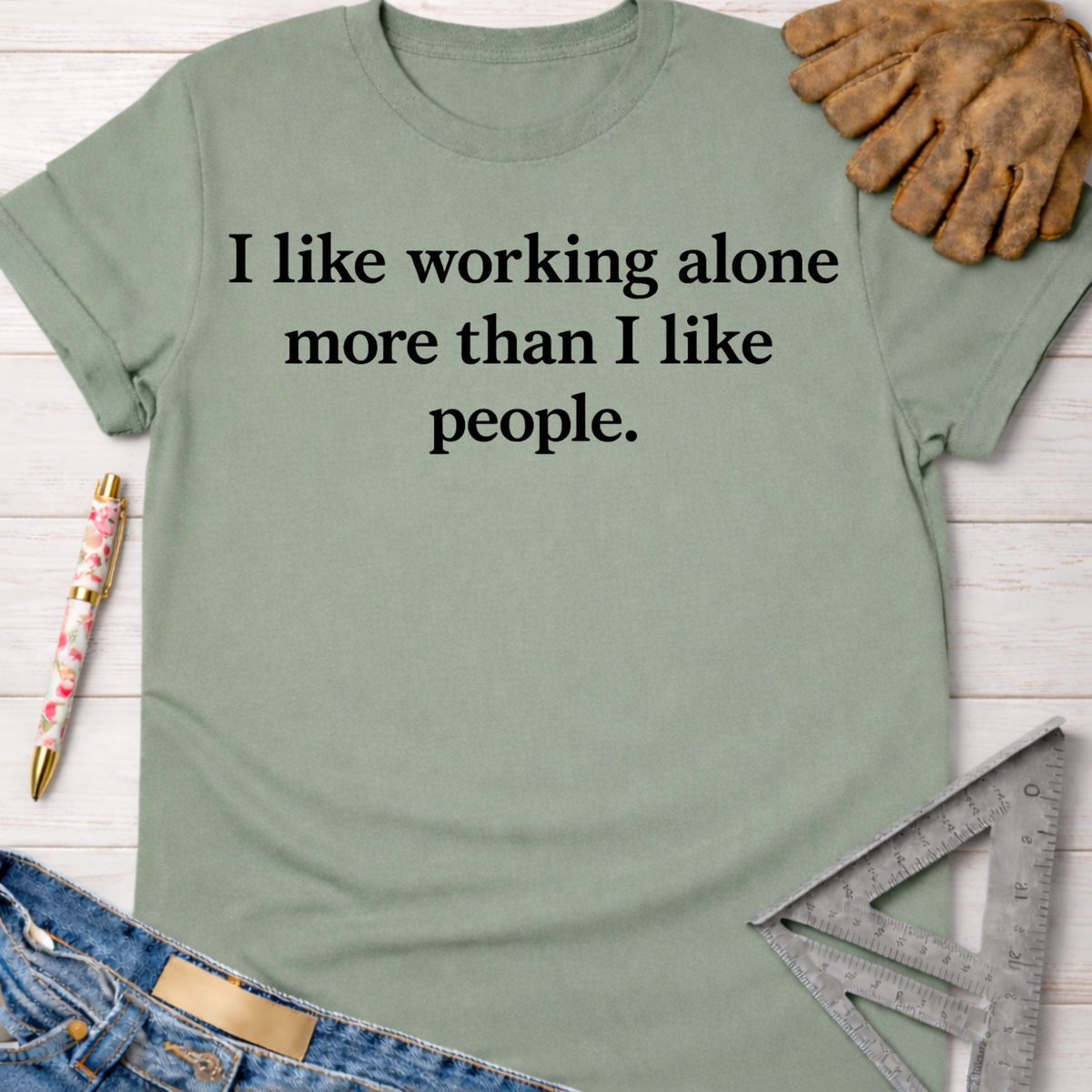 Women's funny woodworking graphic tee shirt for female woodworkers, makers, and DIY builders — Sawdust & Ponytails. Sage green cotton tee with "I like working alone more than I like people" text.