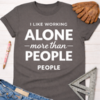 Women's funny woodworking graphic tee shirt for female woodworkers, makers, and DIY builders — Sawdust & Ponytails. Dark gray cotton tee with "I LIKE WORKING ALONE more than PEOPLE" in white text.