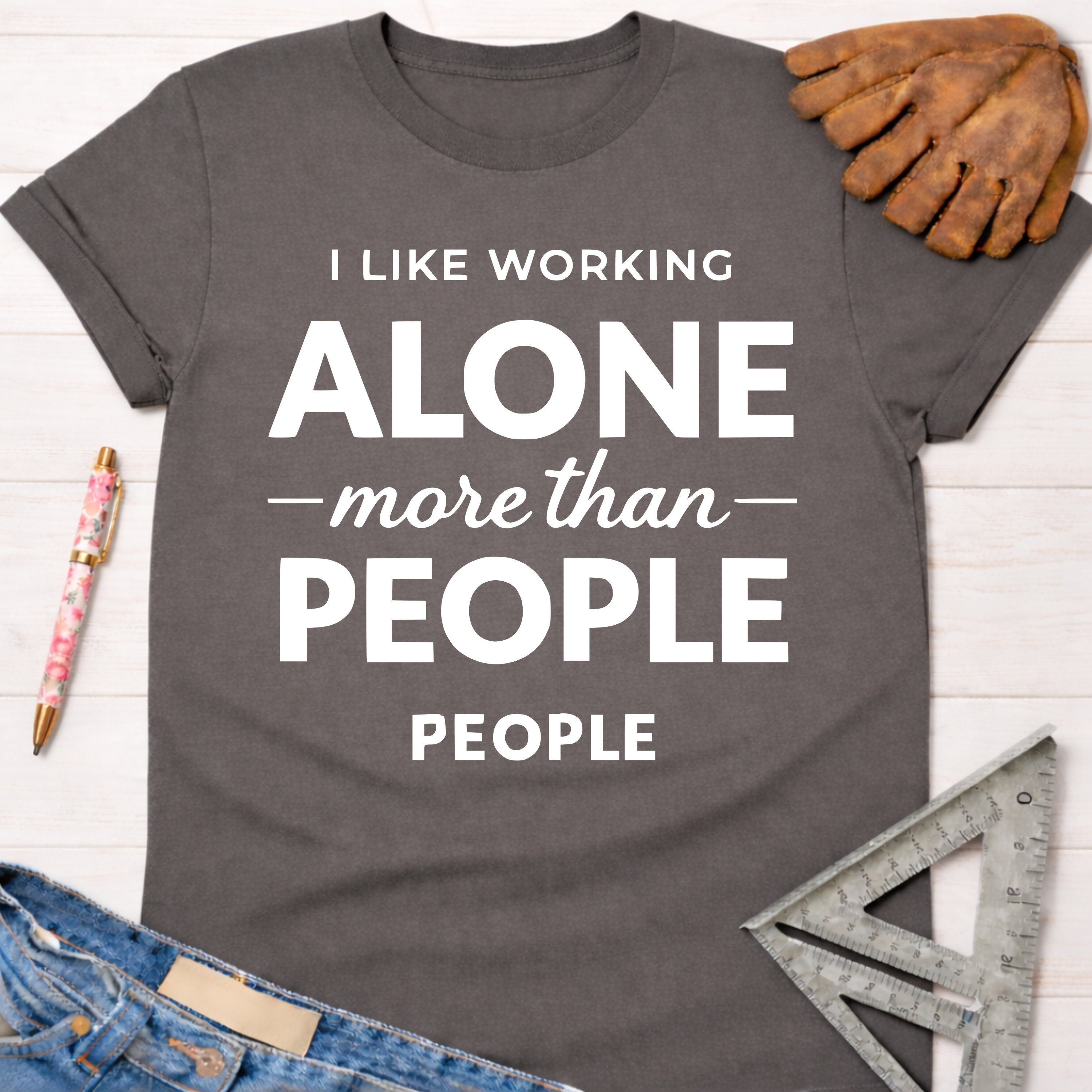 Women's funny woodworking graphic tee shirt for female woodworkers, makers, and DIY builders — Sawdust & Ponytails. Dark gray cotton tee with "I LIKE WORKING ALONE more than PEOPLE" in white text.