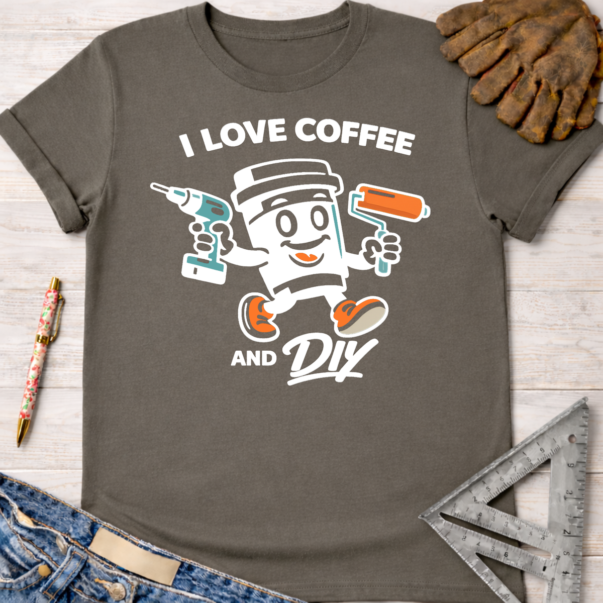 Women's funny woodworking graphic tee shirt for female woodworkers, makers, and DIY builders — Sawdust & Ponytails. Dark gray cotton tee with "I Love Coffee and DIY" text and a coffee cup character holding a drill and paint roller.