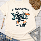 Women's funny woodworking graphic tee shirt for female woodworkers, makers, and DIY builders — Sawdust & Ponytails. Cream t-shirt with "I Love Coffee and DIY" text and a cartoon coffee cup holding a drill and paint roller.