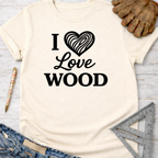 Women's funny woodworking graphic tee shirt for female woodworkers, makers, and DIY builders — Sawdust & Ponytails. Cream t-shirt with "I Love Wood" text and wood grain heart.
