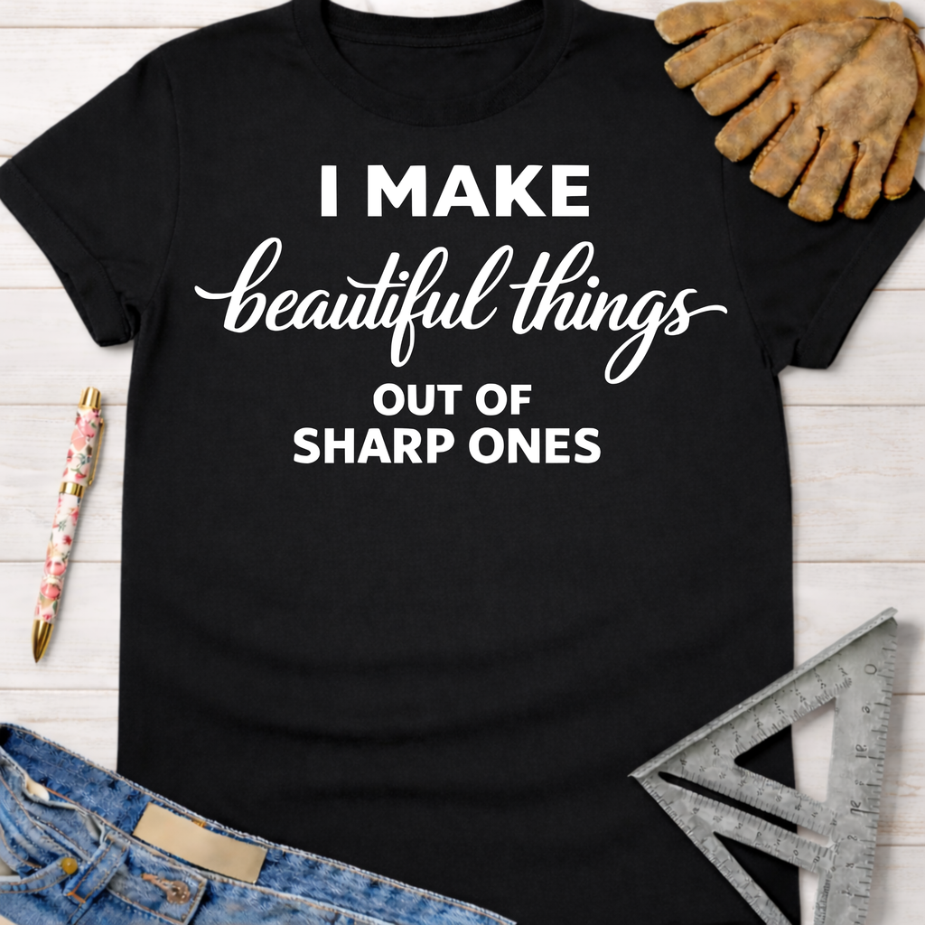 Black cotton tee with "I Make beautiful things OUT OF SHARP ONES" graphic. Women's funny woodworking graphic tee shirt for female woodworkers, makers, and DIY builders — Sawdust & Ponytails.
