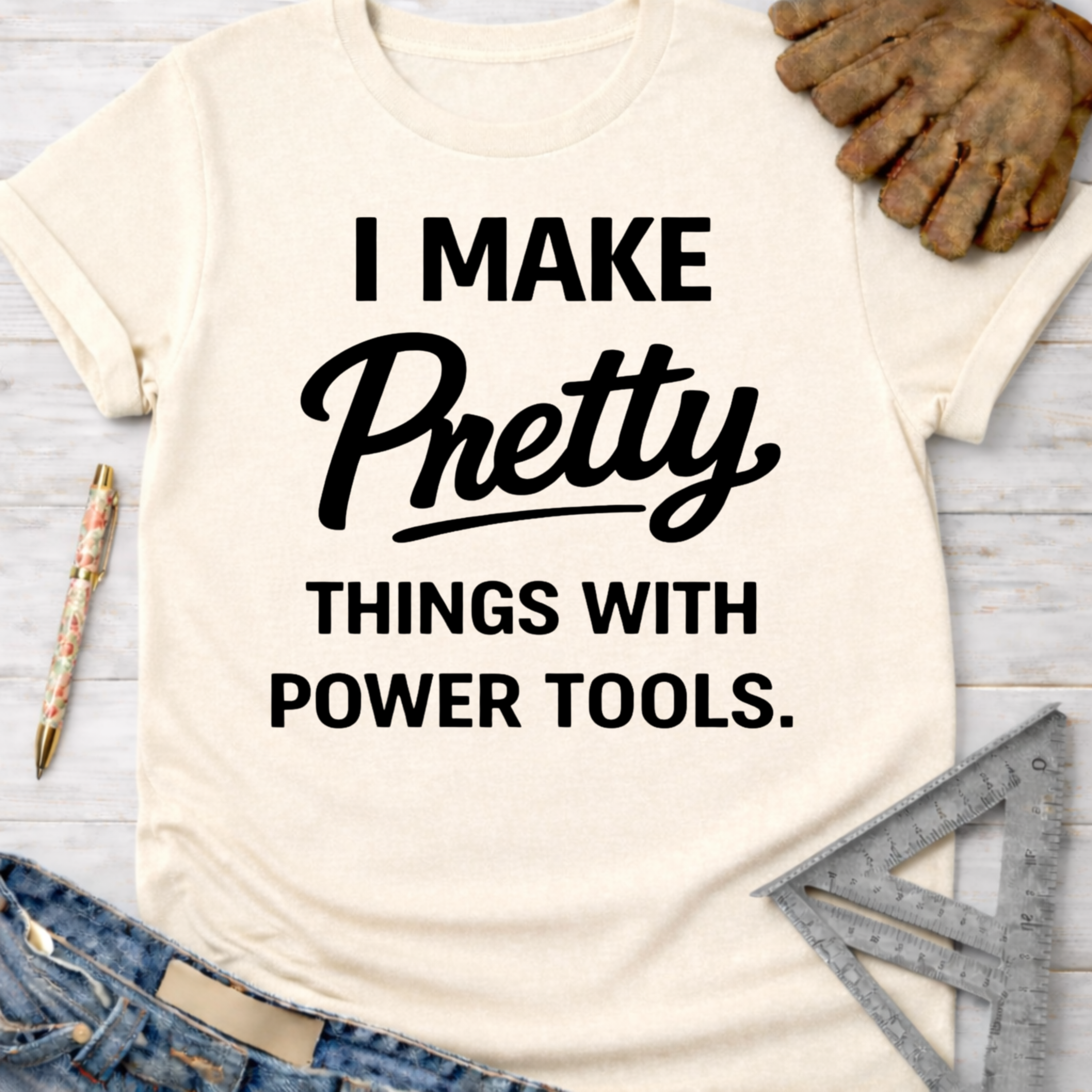 Women's funny woodworking graphic tee shirt for female woodworkers, makers, and DIY builders — Sawdust & Ponytails. Cream t-shirt with "I Make Pretty Things With Power Tools" in black text.