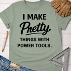 Women's funny woodworking graphic tee shirt for female woodworkers, makers, and DIY builders — Sawdust & Ponytails. Sage green cotton tee with "I Make Pretty Things With Power Tools" text.