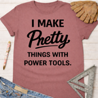 Women's funny woodworking graphic tee shirt for female woodworkers, makers, and DIY builders — Sawdust & Ponytails. Mauve short-sleeve tee with "I Make Pretty Things With Power Tools" in black text.