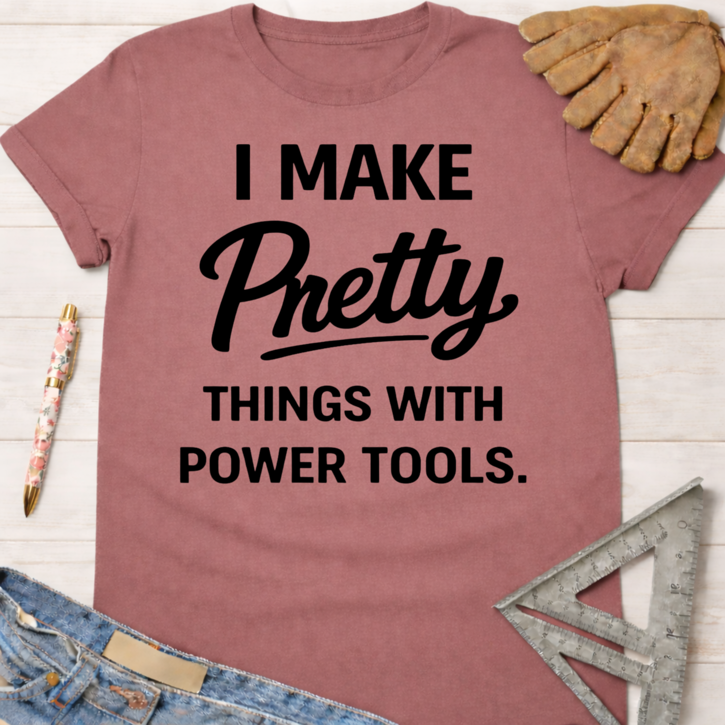 Women's funny woodworking graphic tee shirt for female woodworkers, makers, and DIY builders — Sawdust & Ponytails. Mauve short-sleeve tee with "I Make Pretty Things With Power Tools" in black text.