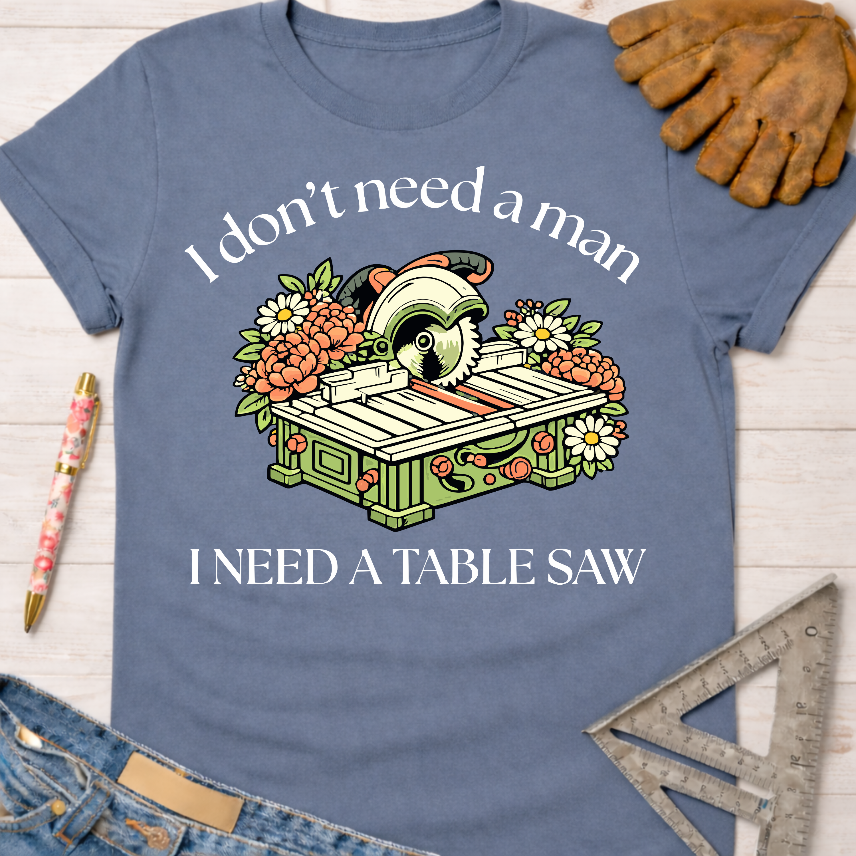 Women's funny woodworking graphic tee shirt for female woodworkers, makers, and DIY builders — Sawdust & Ponytails. Blue cotton t-shirt with "I don't need a man, I need a table saw" graphic.